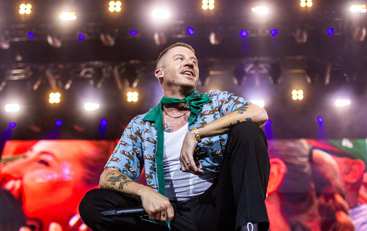 Macklemore onstage with a delightful duck-print short-sleeve shirt.