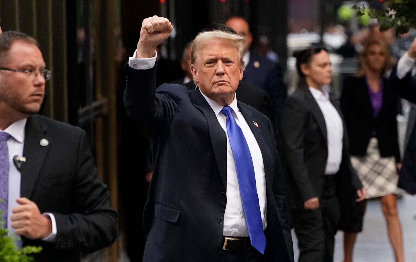 Donald Trump holds up a fist outside the Trump Building after his conviction.