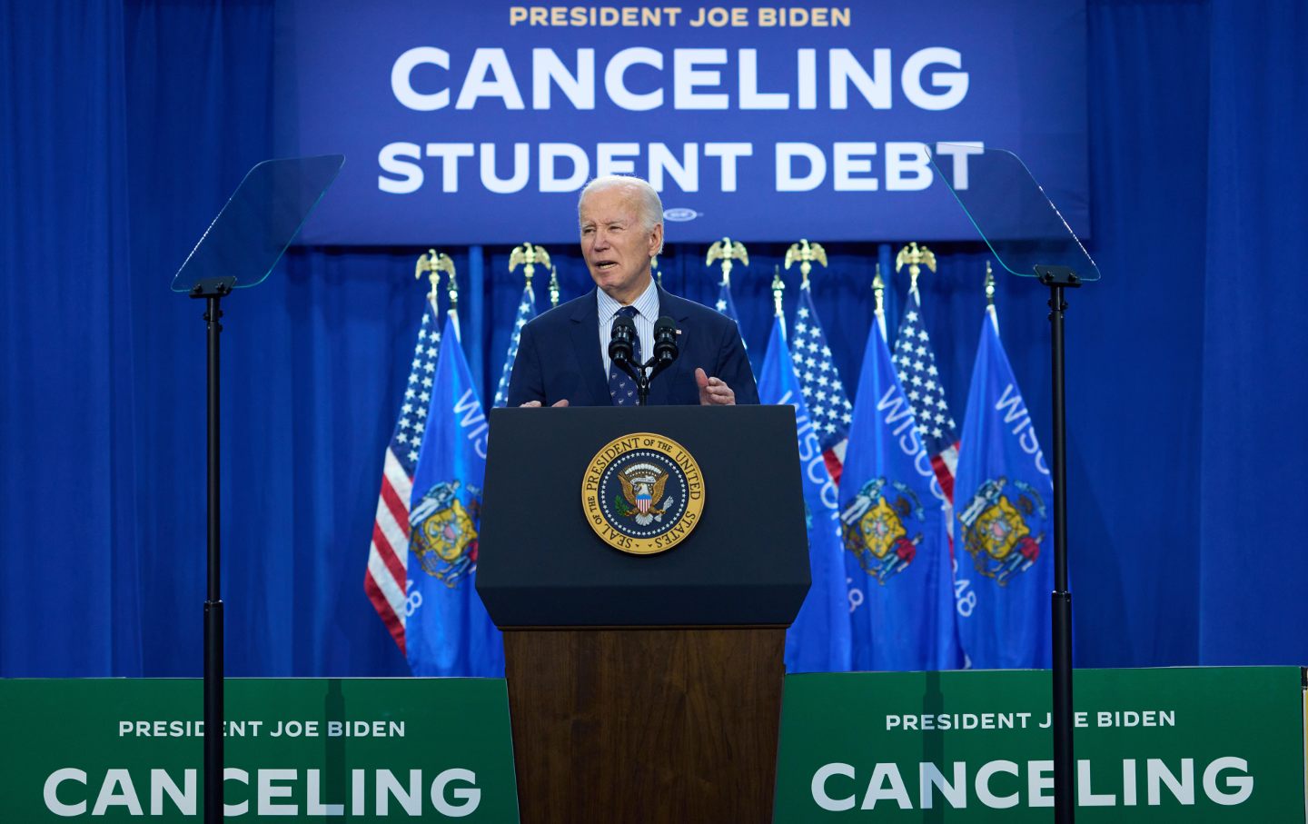 President Joe Biden at a podium in front of a banner reading 