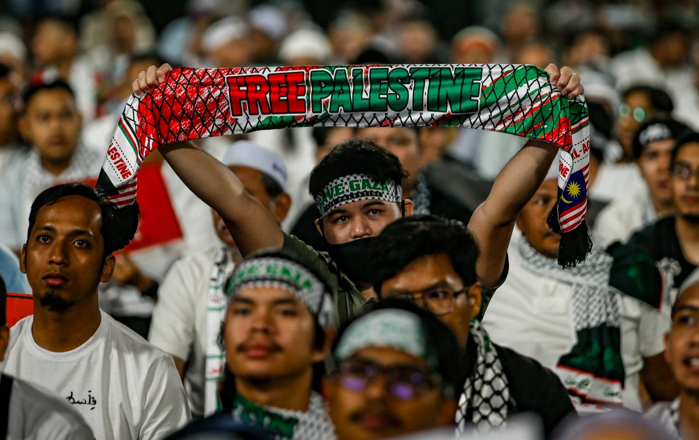 A pro-Palestinian demonstrators display Free Palestine mafla during a peaceful rally at the Bukit Jalil indoor stadium in Kuala Lumpur, Malaysia.