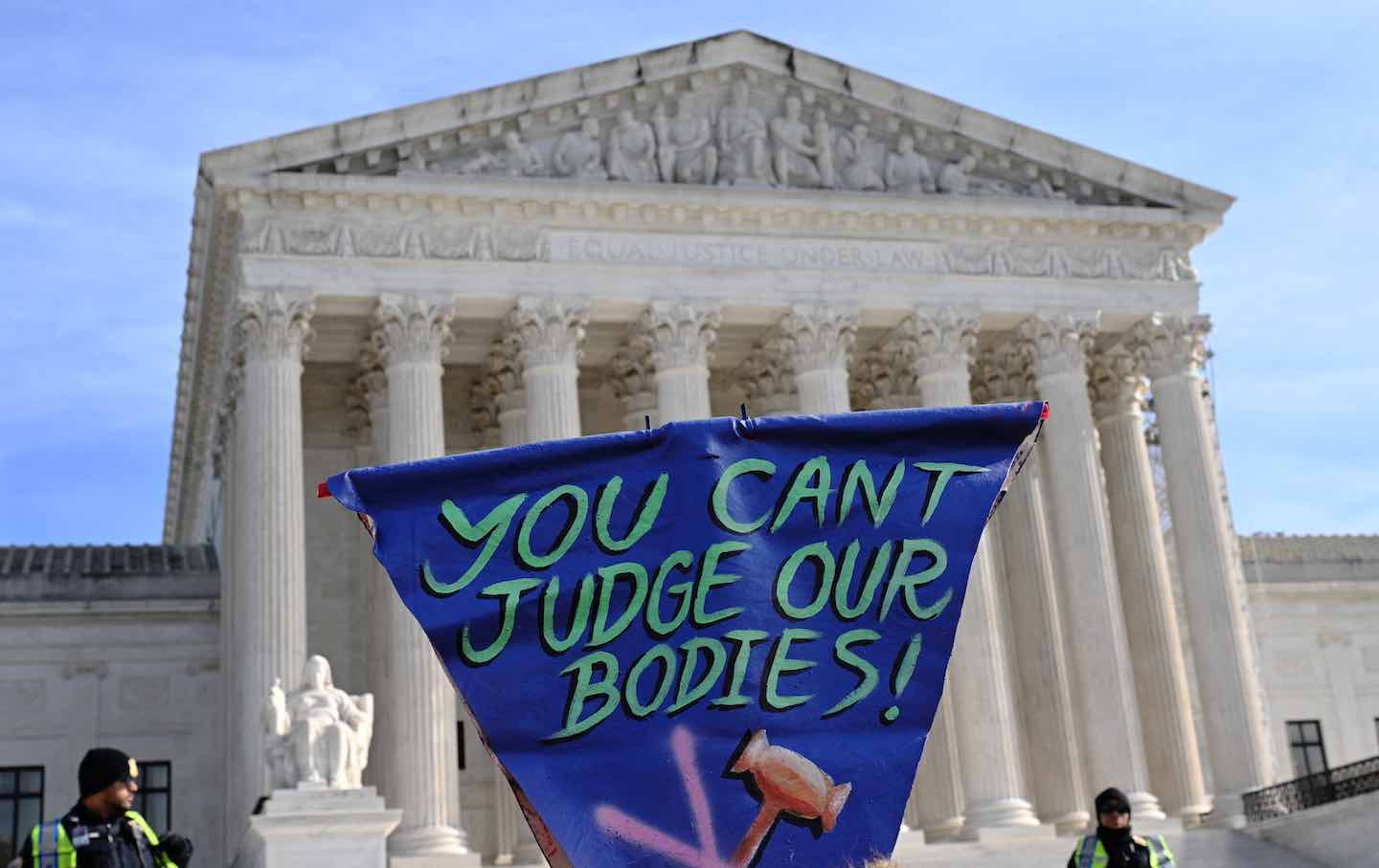 People hold signs outside the US Supreme Court Building on December 4, 2024, in Washington, DC, during oral arguments on whether states can ban certain medical treatments for young people.