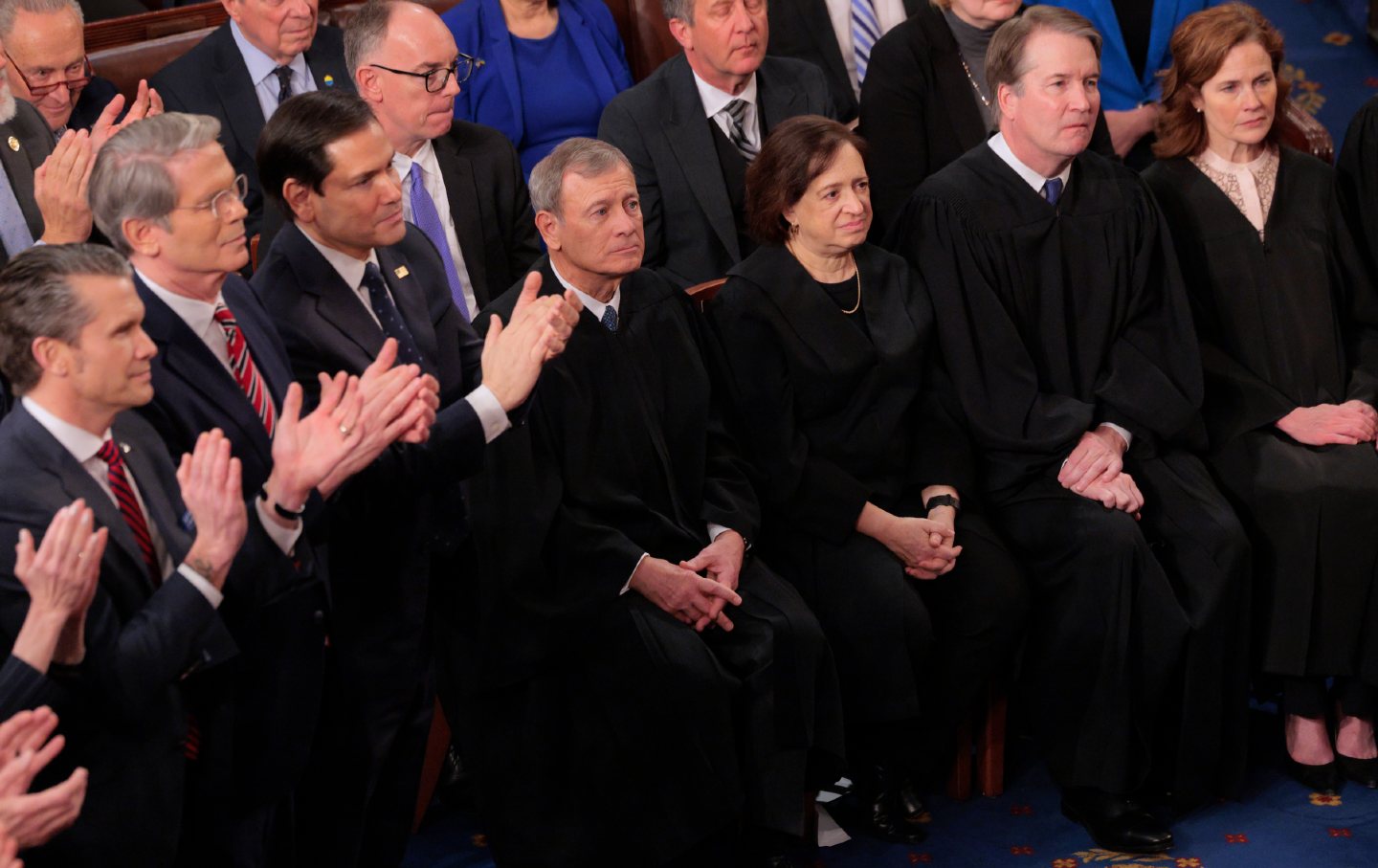 Members of the Cabinet of Ministers Donald Trump (L) stand and applaud when members of the Supreme Court remain during Trump's return for a joint Congress session.