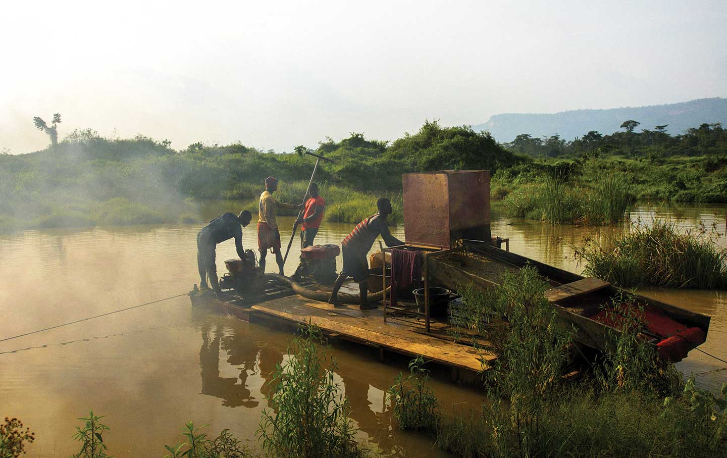 A group of men engaged in illegal gold mining look for specks of gold in Kibi in southern Ghana.