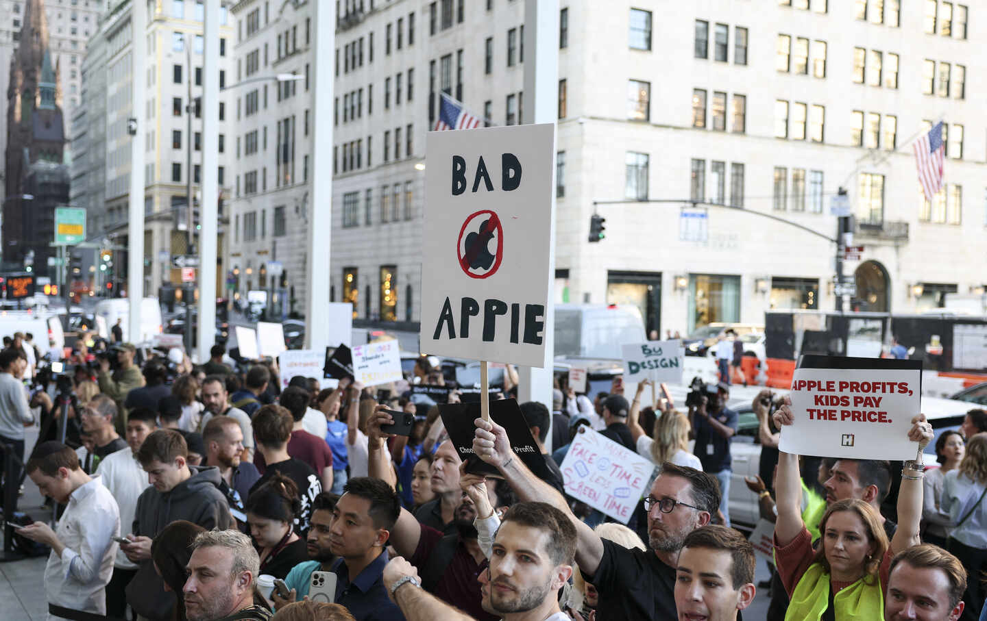 People protest Apple as others line up for the release of iPhone 17 models outside the Apple store in New York on September 19, 2025.