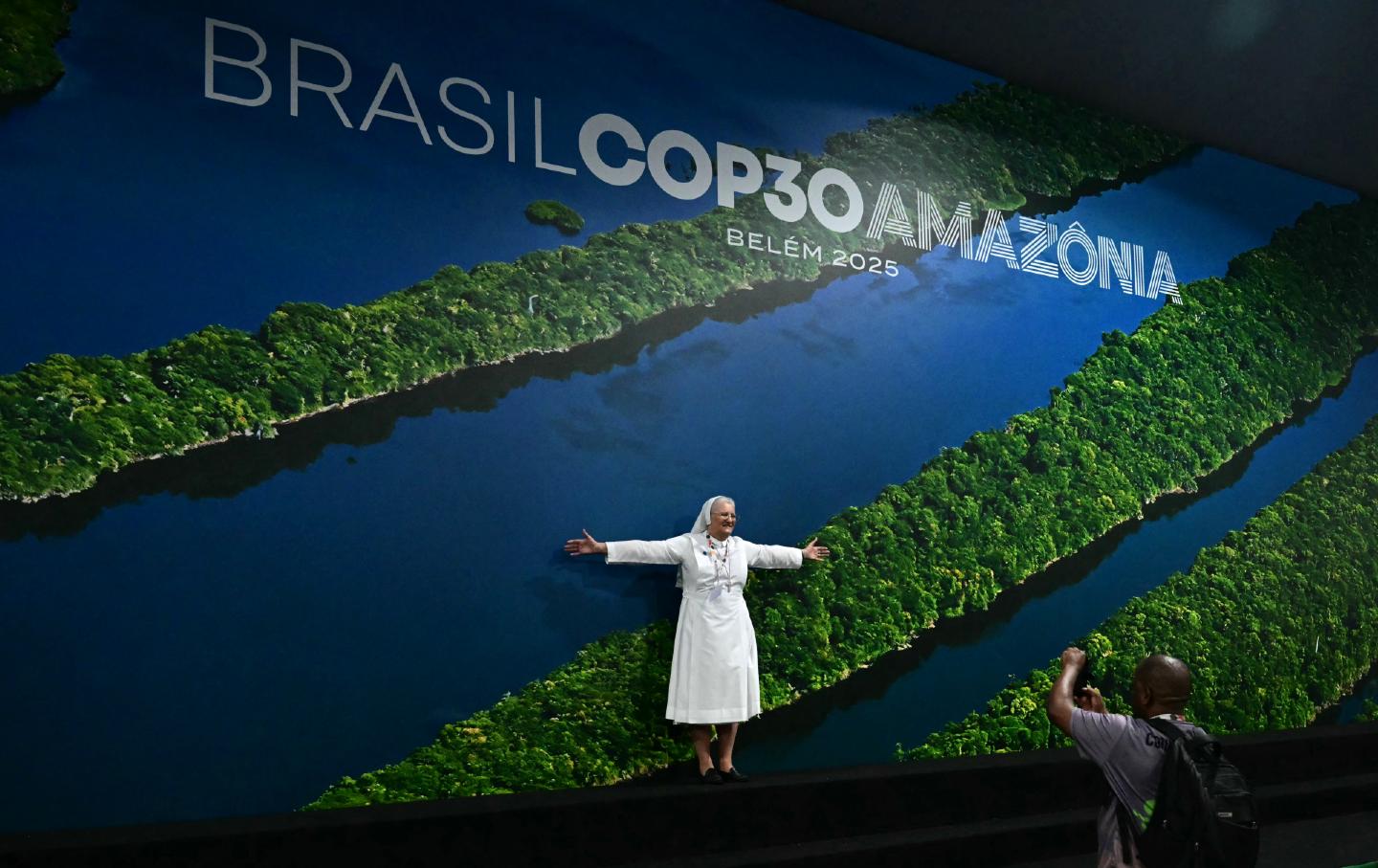 Monja frente al mural de la Cop30 en Brasil
