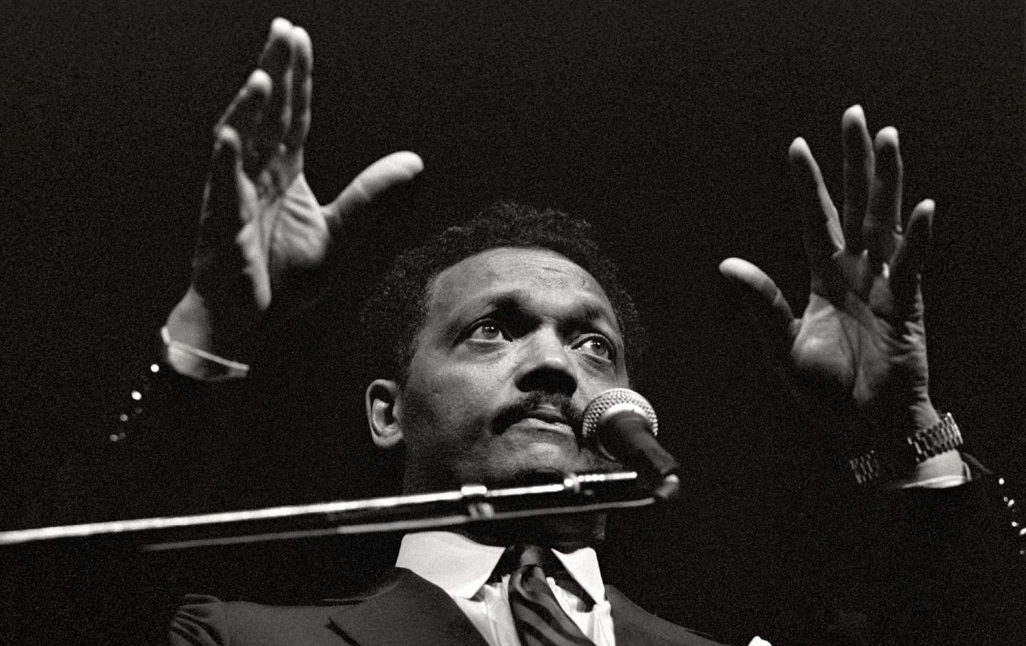 Jesse Jackson speaking into a microphone in 1989.