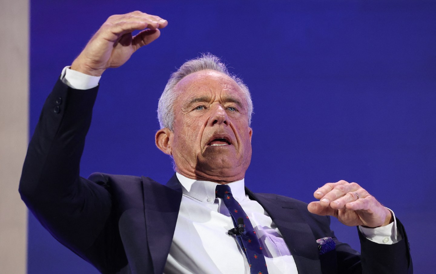 Robert F. Kennedy Jr. raising arms in expression.