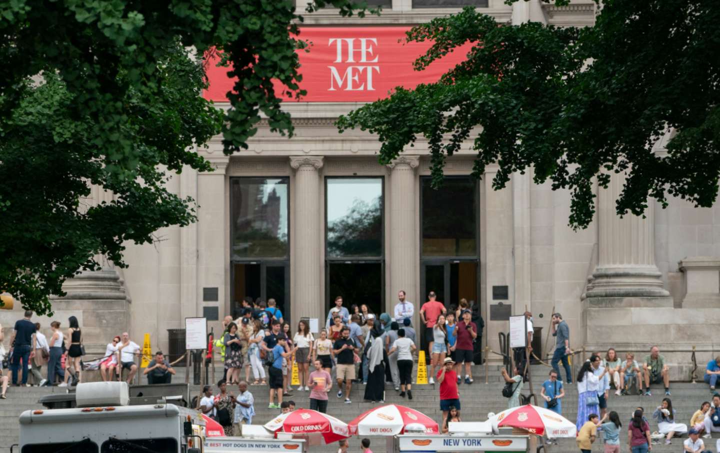 People enjoy a break in thunder storms on the steps of the Met Tuesday July 4, in Manhattan New York.