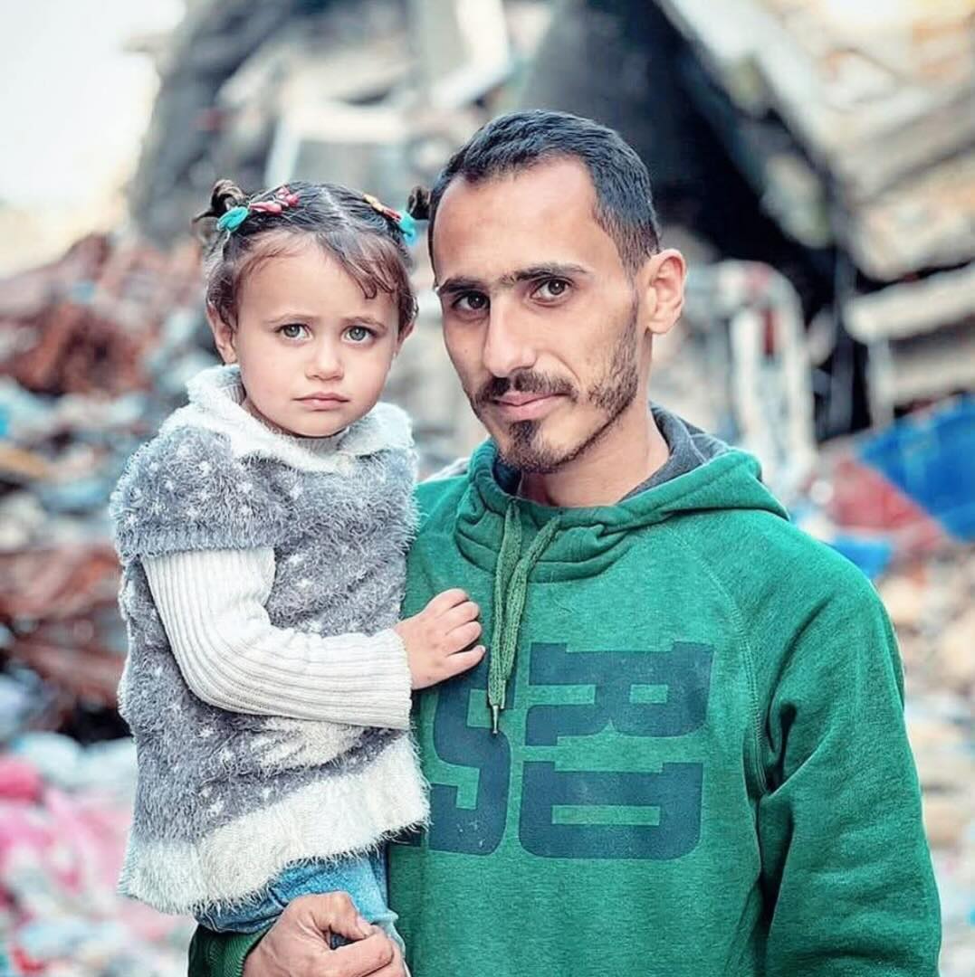 Abdel Rahman Jebril, 33, carrying his daughter, Lia, 4.