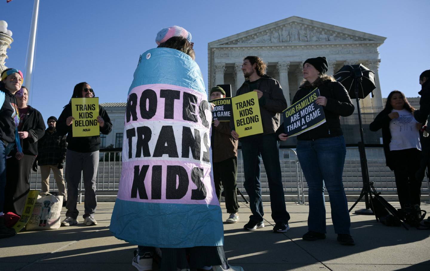 LGBTQ+ rights advocates rally outside the US Supreme Court as justices hear arguments in challenges to state bans on transgender athletes in women's sports.