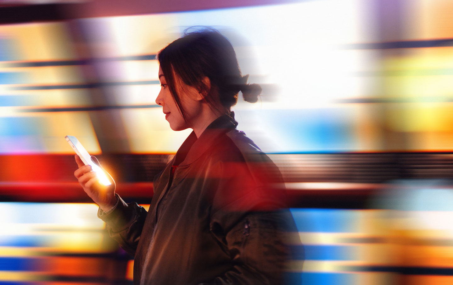 Young woman holding smartphone, with a computer-generated background.