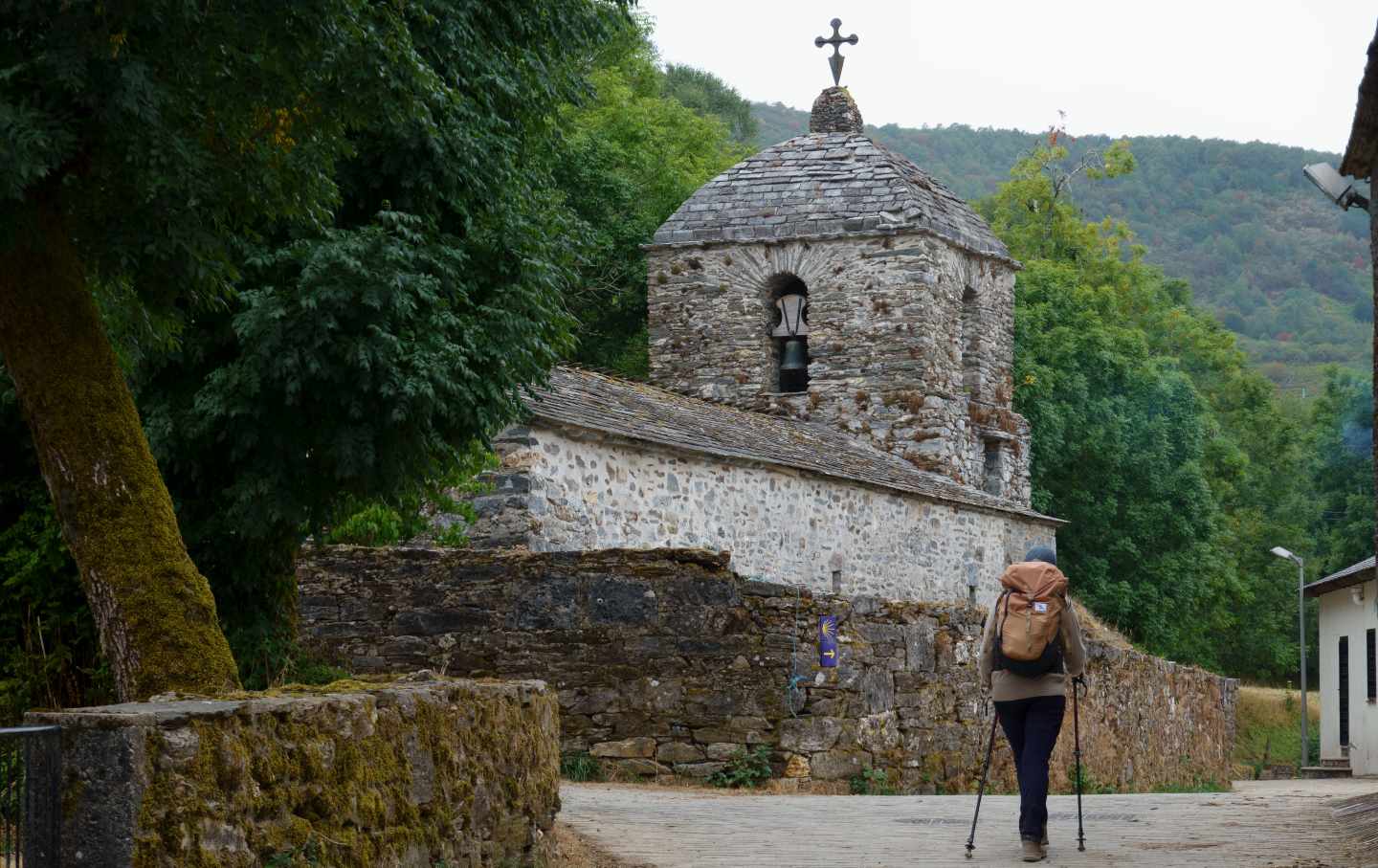 A pilgrim approaches the church in the village of Hospital on the Camino de Santiago.