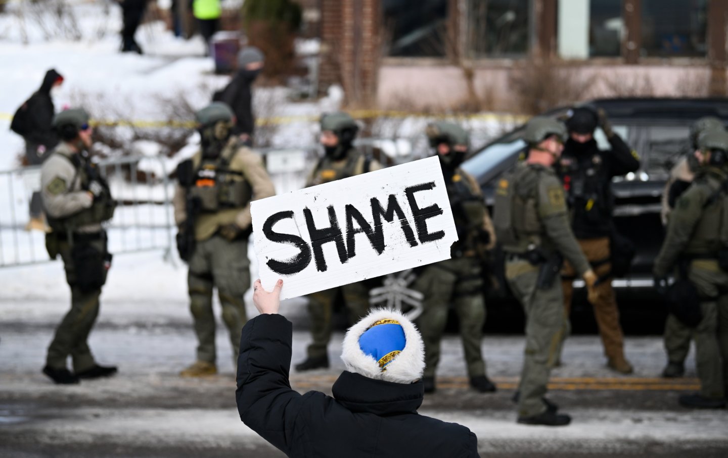 Law enforcement and a protester on the scene after an ICE agent shot and killed a woman in Minneapolis on January 7.