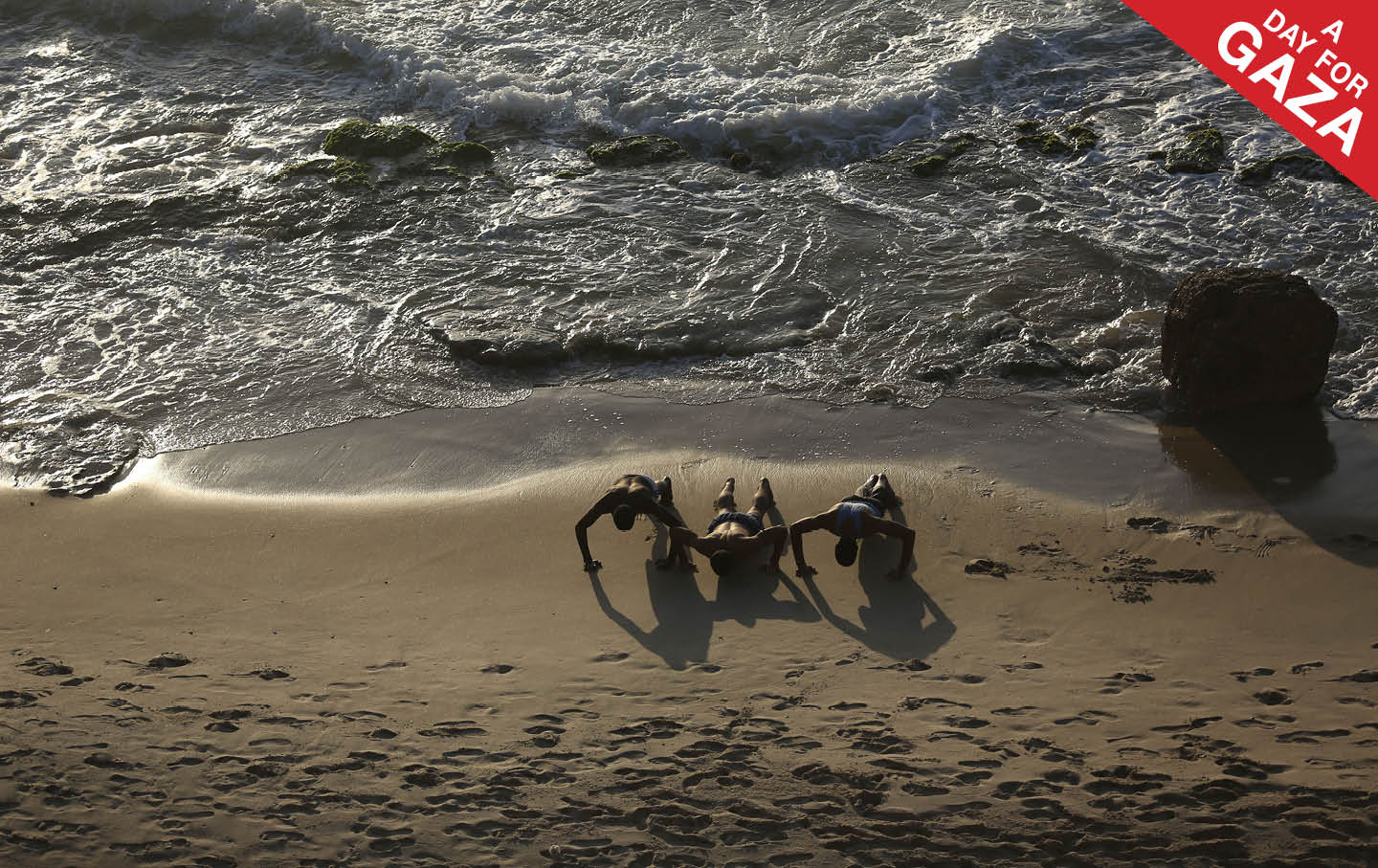 Palestinians exercise on a beach in the Deir al-Balah Palestinian refugee camp on June 14, 2023.