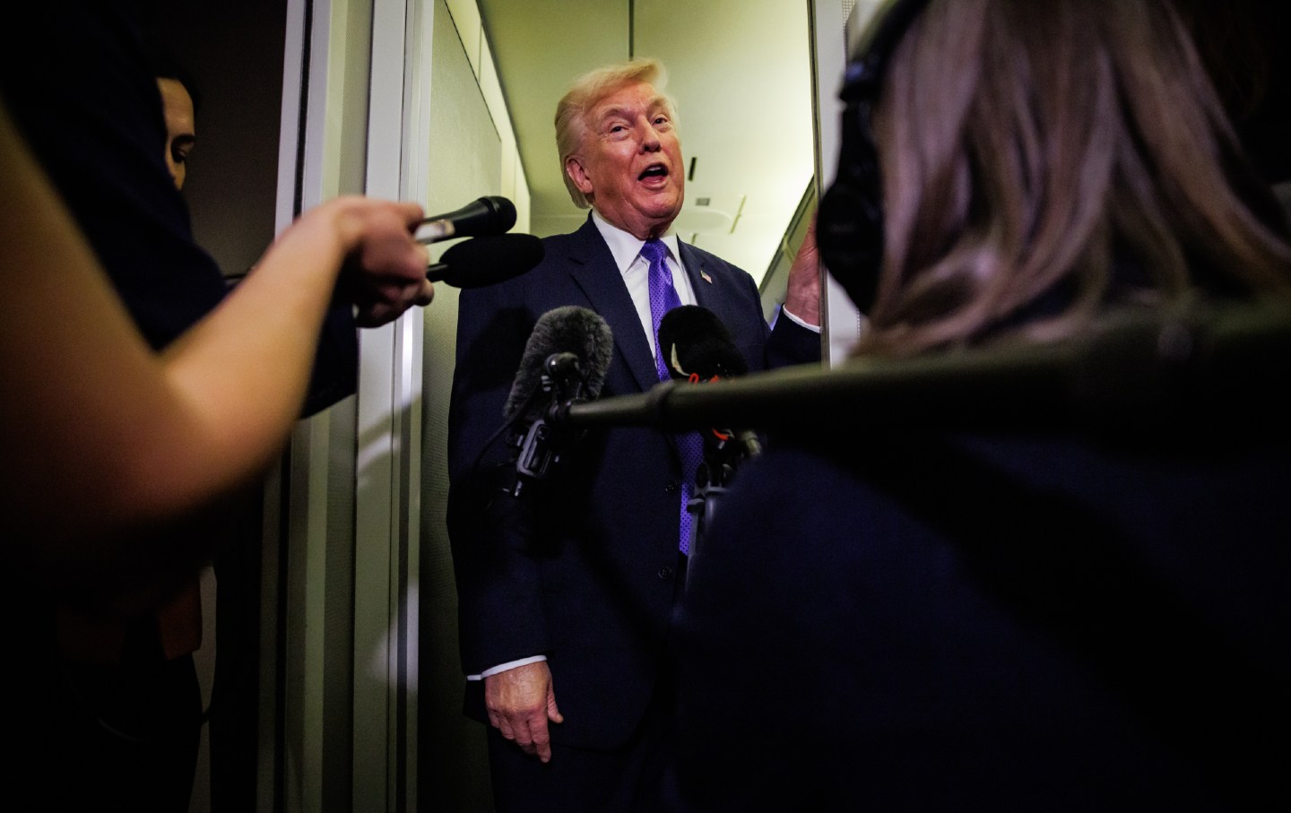 President Donald Trump gaggles with reporters while aboard Air Force One on February 6, 2026, en route to Palm Beach, Florida.