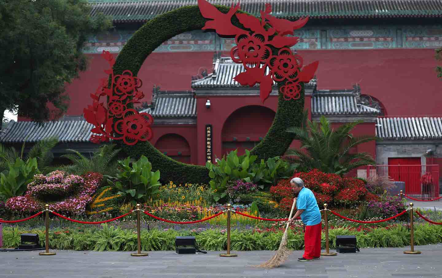 A woman cleans the street near the Drum Tower in Beijing, 2025.