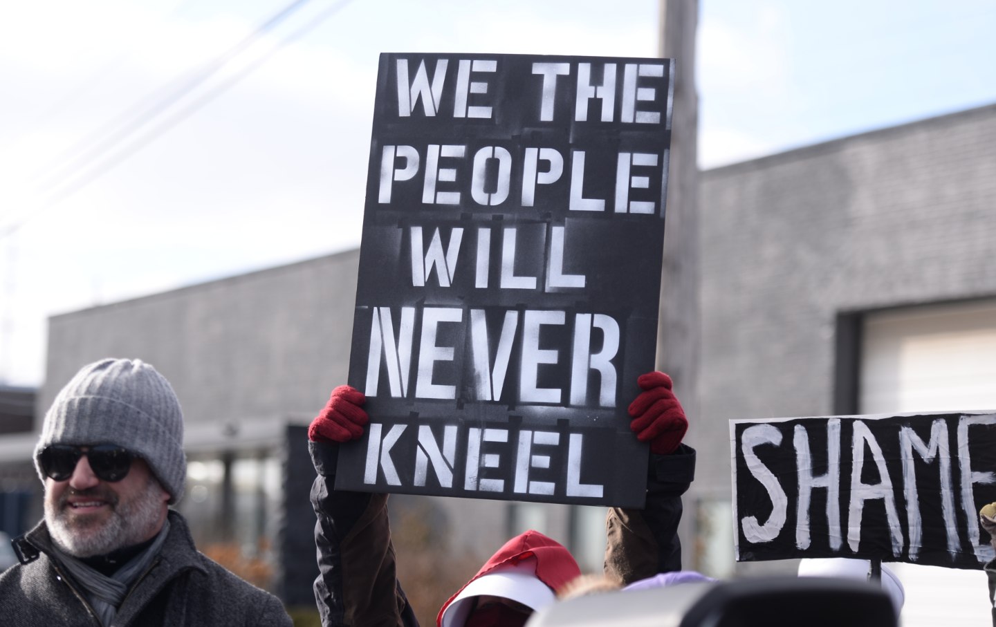 A protester holds a sign reading 