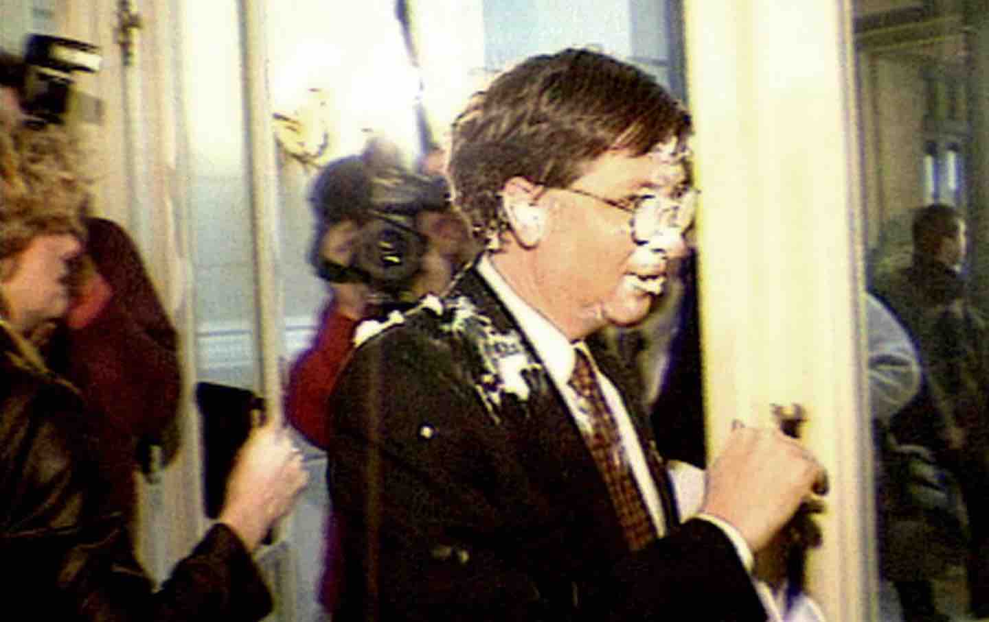 A video still of Bill Gates walking past reporters after being hit by a cream pie in Brussels, Belgium, 2000.
