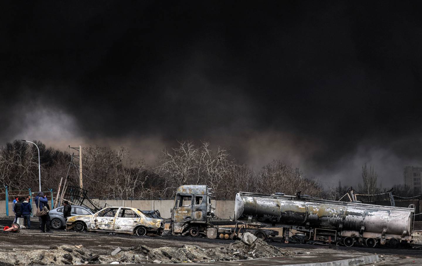A dark smoke cloud engulfs destroyed vehicles following a US-Israeli airstrike on the Shahran oil refinery in northwestern Tehran on March 8, 2026.