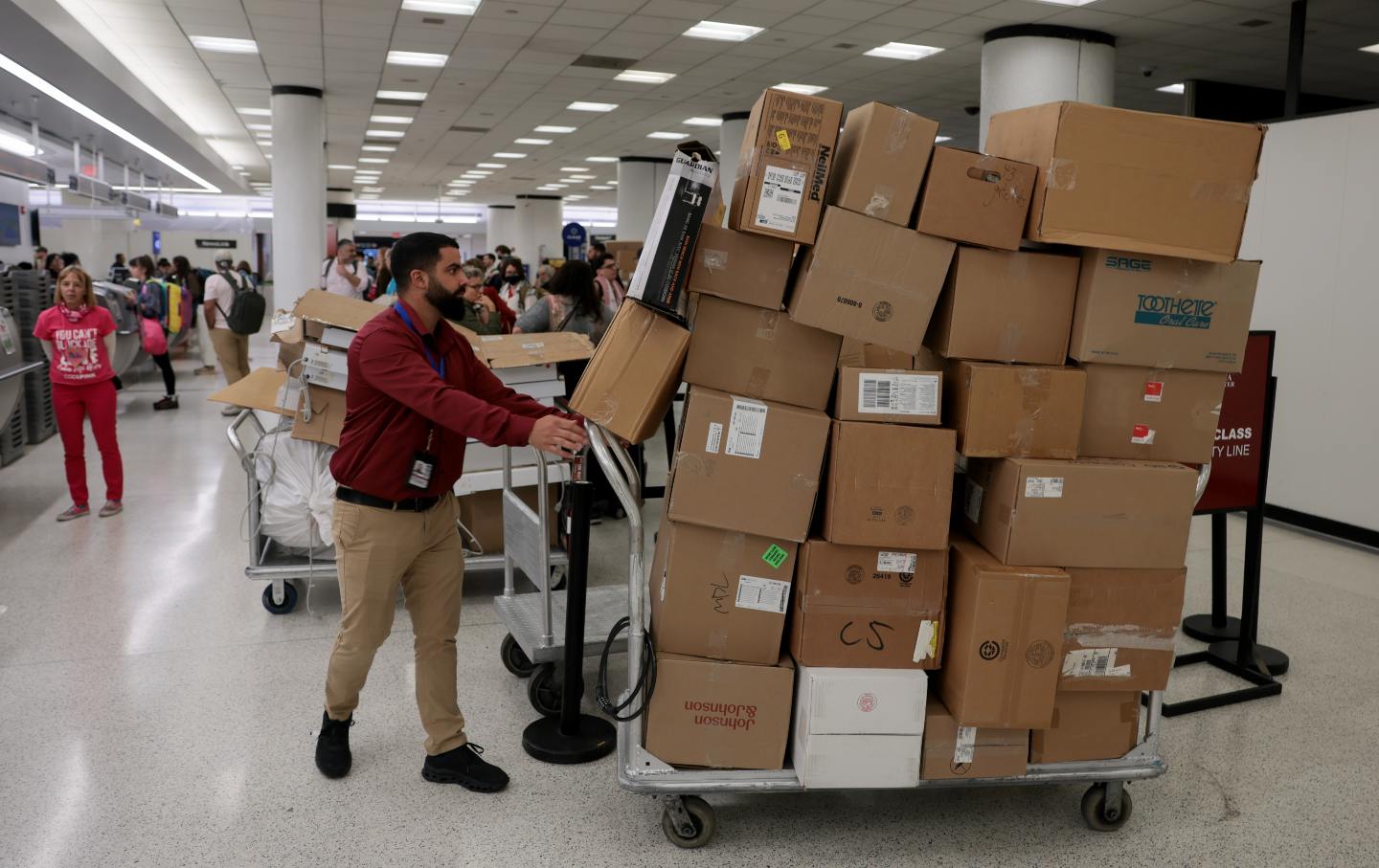 Activists from the Nuestra América Convoy prepare to load boxes of humanitarian aid onto a conveyor belt at Miami International Airport in Miami, Florida, on March 20, 2026. 
