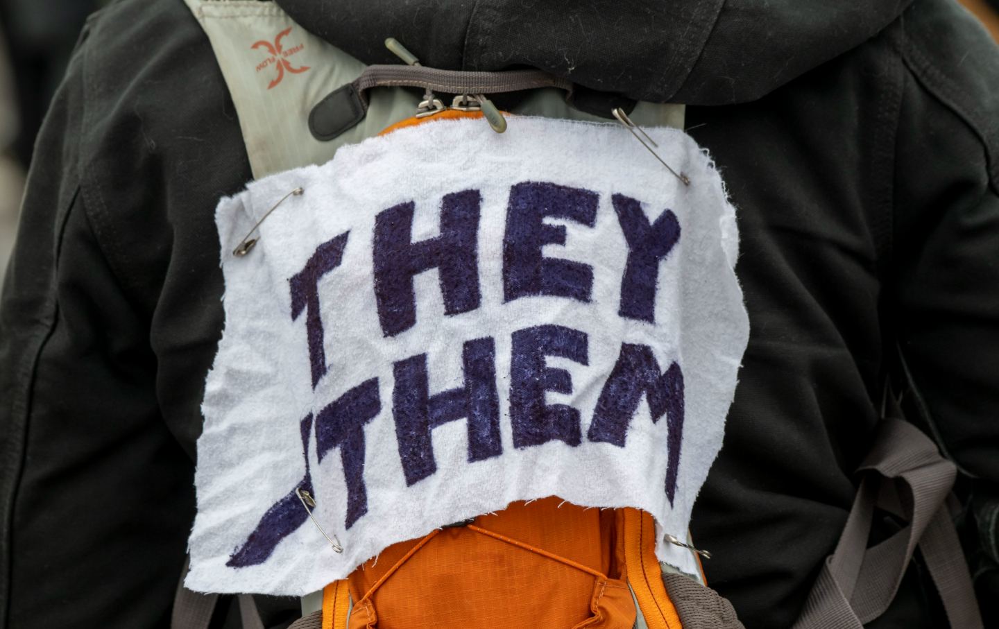A protestor wears a piece of fabric with the pronouns 'they/them' pinned to them as Minneasotans hold a rally to raise awareness of the increasing number of attacks on transgender children, at the Capitol in St Paul area of Minnesota, 6th March 2022.