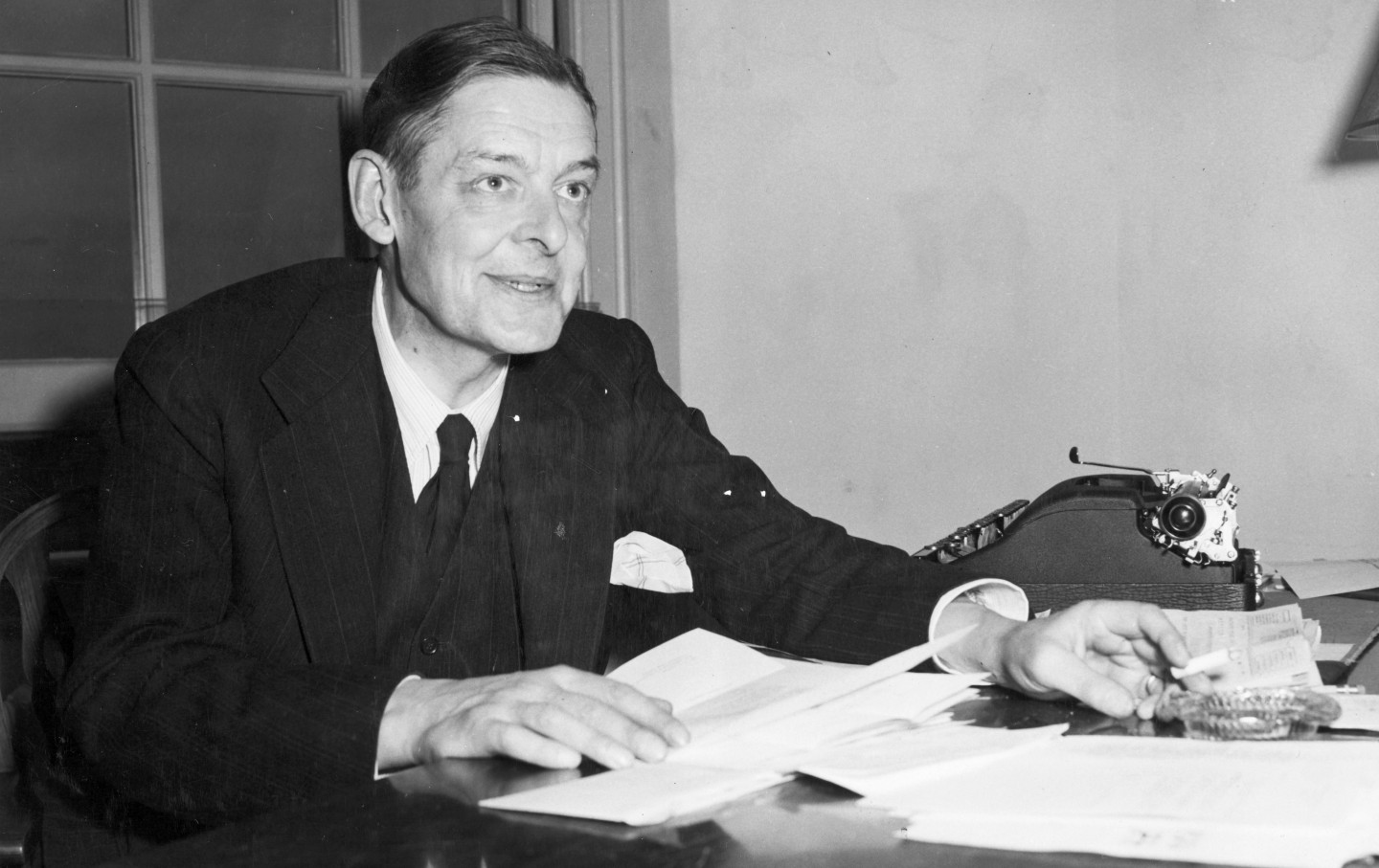 T.S. Eliot inspecting manuscripts. Undated photograph.