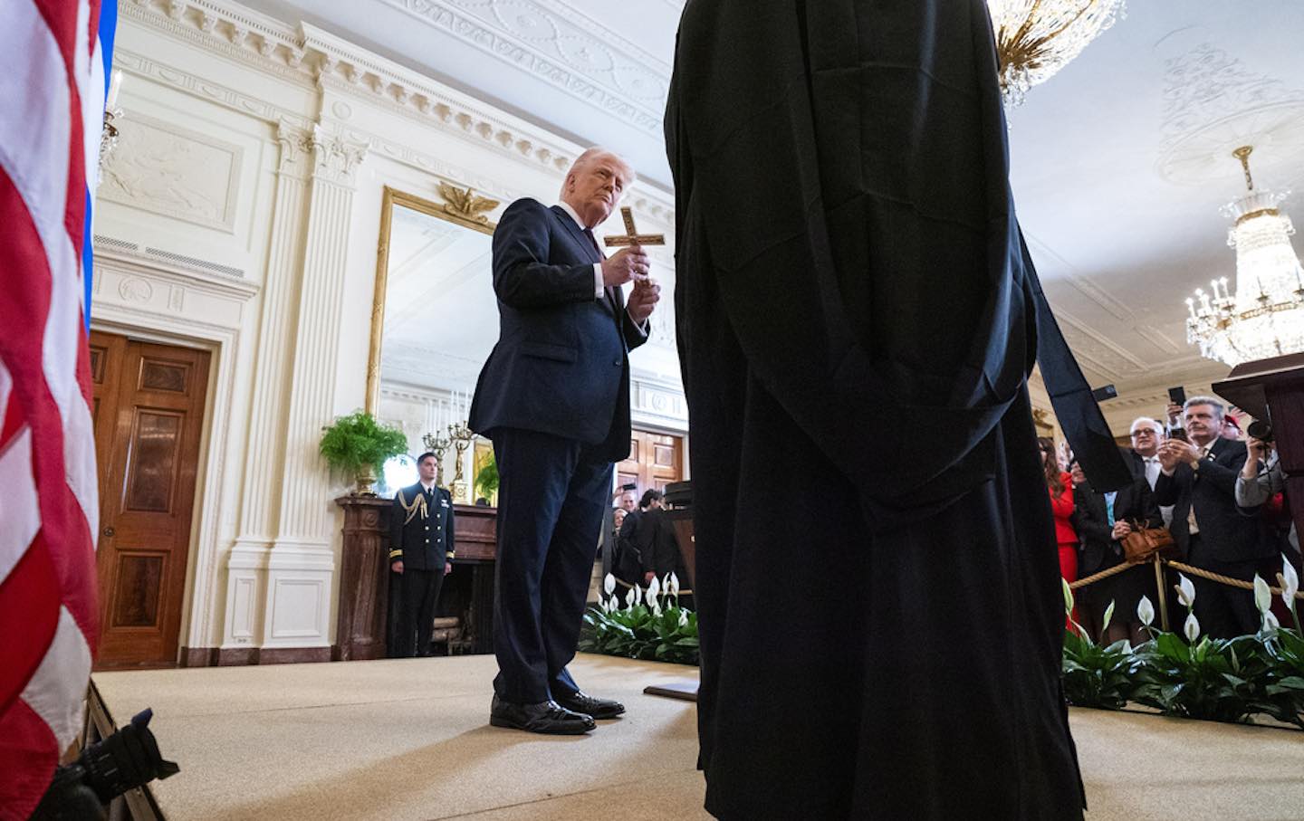President Donald Trump holds a cross given to him by Archbishop Elpidophoros of the Greek Orthodox Archdiocese of America.