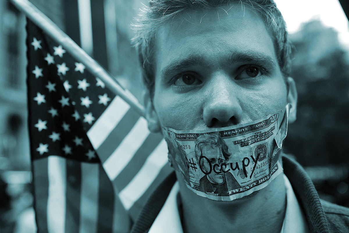 A demonstrator satirizes the stifling effects of corporate money on free speech during the Occupy Wall Street protests of 2011.