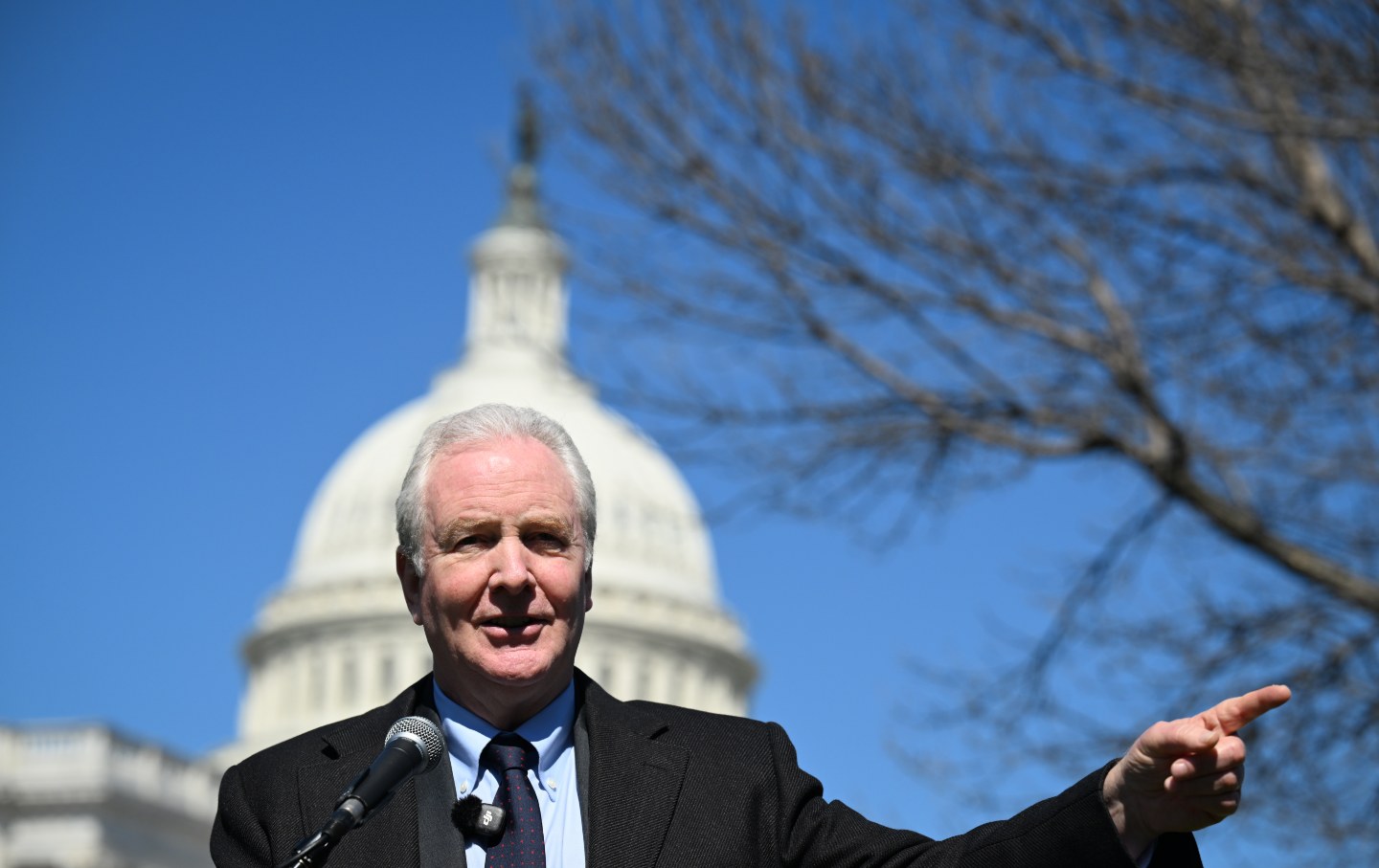 Sen. Chris Van Hollen (D-MD) speaks in front of a memorial composed of shoes and backpacks, symbolizing those killed in the bombing of the Minab elementary school and other civilians in Iran, in Washington, DC, on March 18, 2026.