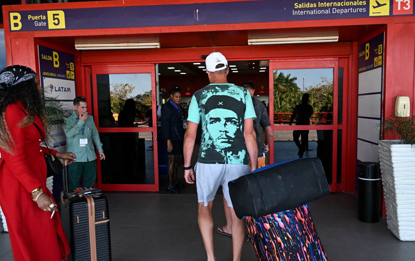 A Russian tourist wearing a shirt with the face of Cuban revolutionary Che Guevara prepares to board a return flight at Jose Marti International Airport in Havana, Cuba, on February 16, 2026.