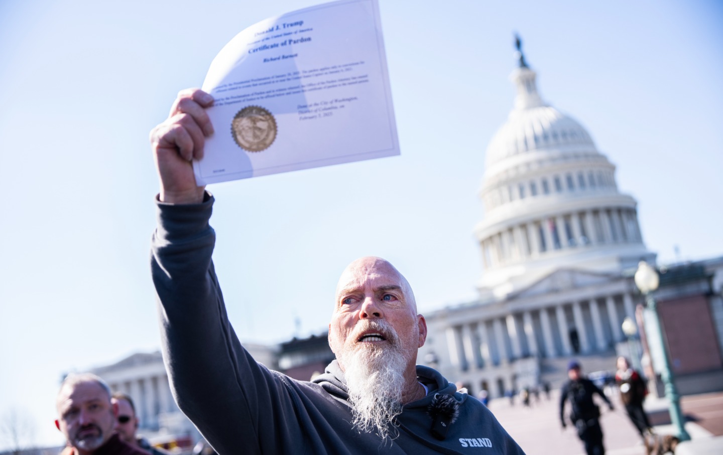 Richard “Bigo” Barnett, who was convicted of for his actions at the January 6 riot, shows off his pardon from President Donald Trump, at a news conference on February 21, 2025, with members of the Proud Boys, Oath Keepers, and other January 6 offenders who received pardons or commuted sentences.