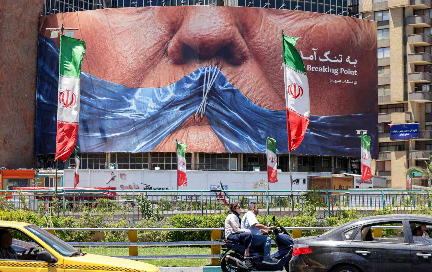 Motorists drive past a political billboard featuring US President Donald Trump and the Strait of Hormuz at Valiasr Square in Tehran, Iran, on May 26, 2026.