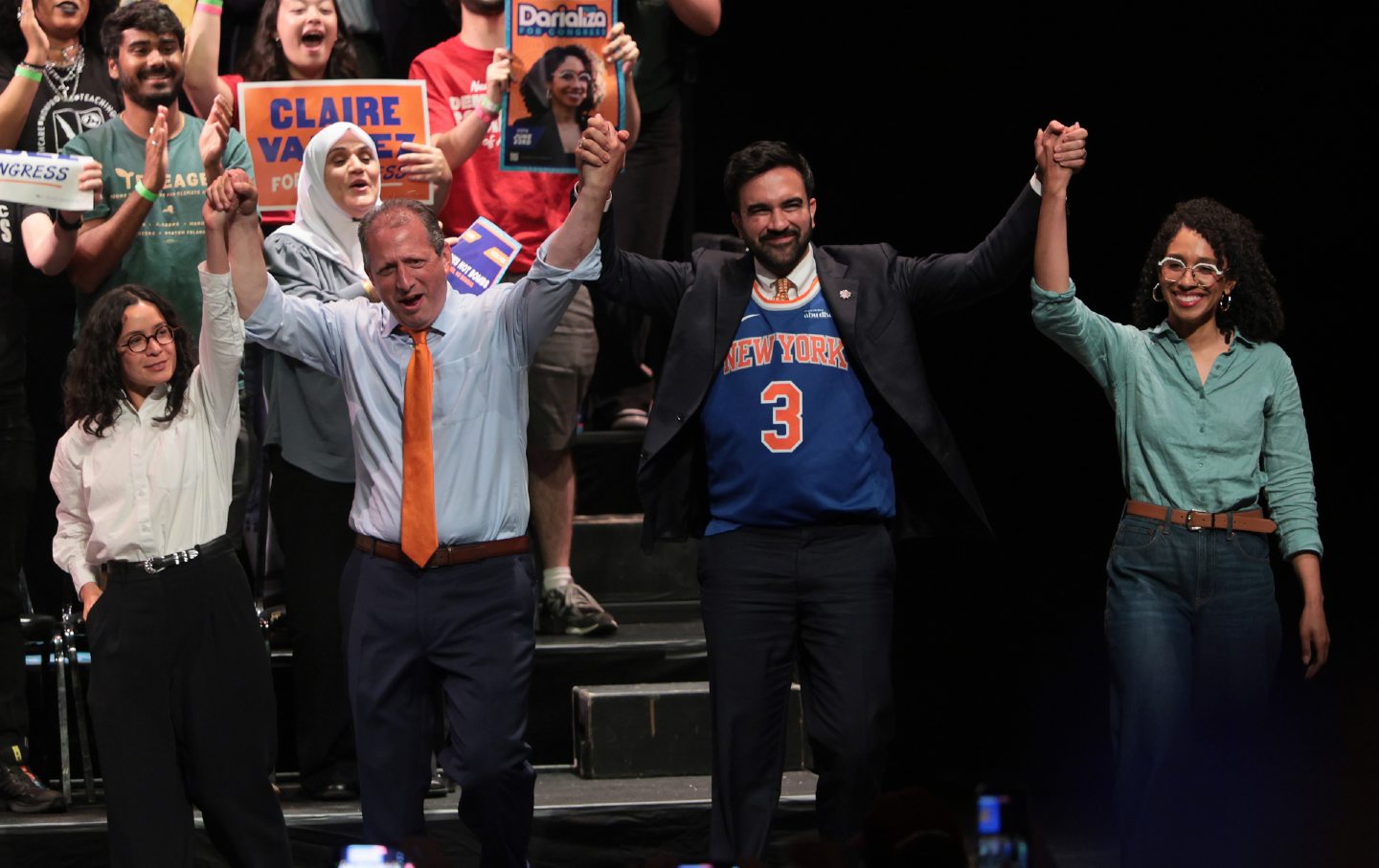 Congressional candidates Claire Valdez, Brad Lander, and Darializa Avila Chevalier raised their hands with Mayor Zohran Mamdani (in the Knicks shirt) during a Get Out the Vote rally at King's Theater on June 18, 2026, in New York City.