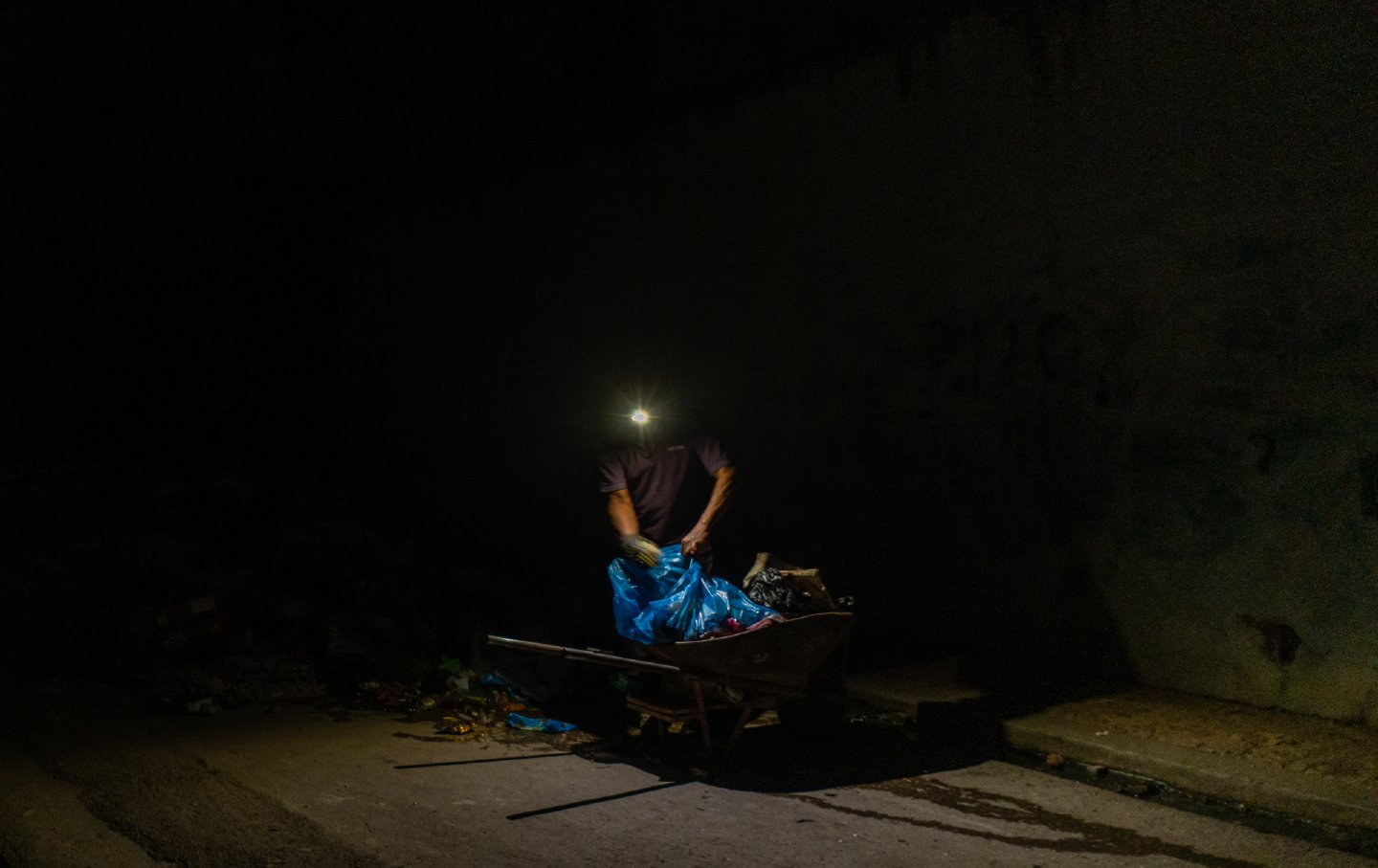 A man searches through trash in the dark in Havana, Cuba, on June 11, 2026, as widespread shortages affect daily life.