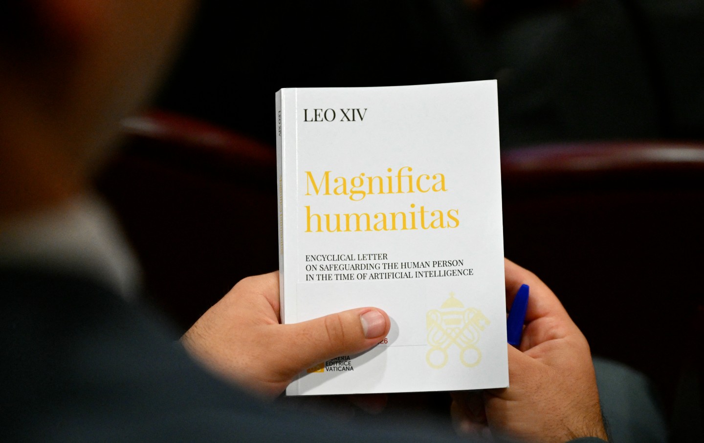 On the day of its promulgation, a person holds Pope Leo XIV’s Encyclical Letter “Magnifica Humanitas,” focused on the rise of artificial intelligence, at the Vatican on May 25, 2026.
