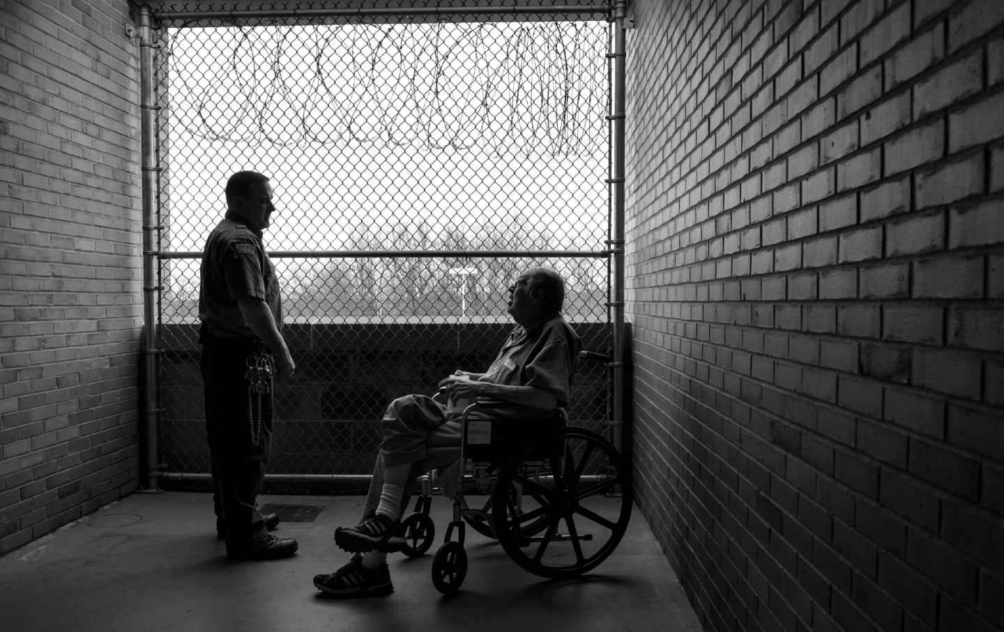 Doherty Tim, senior officer specialist, Federal Bureau of Prisons, chats with Ben Lupo, 64, from Youngstown, Ohio, at Devens federal prison in Massachusetts, on Tuesday, April 22, 2015. (