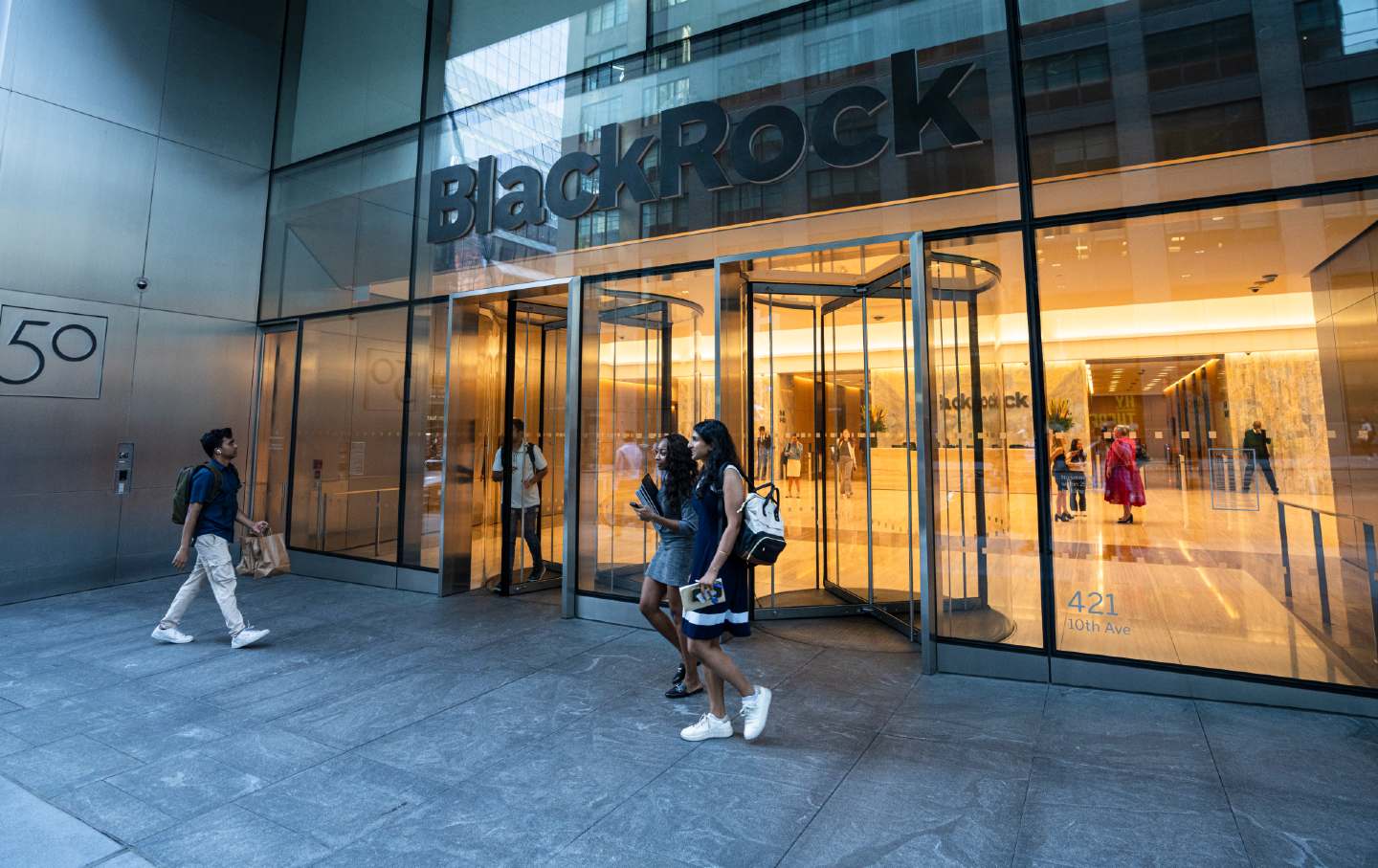 Young people walking in front of the BlackRock corporate headquarters in Hudson Yards.