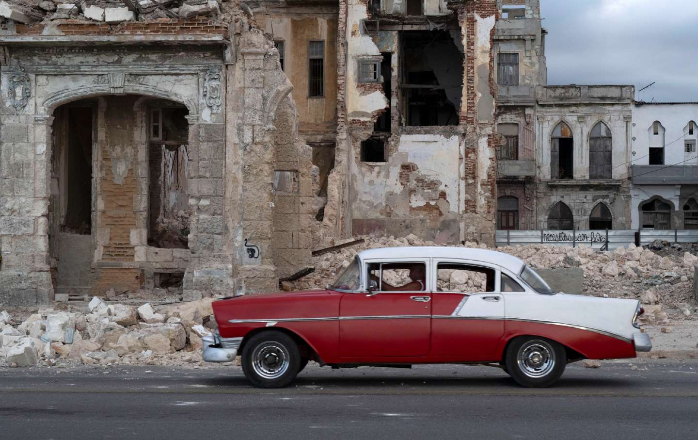 An old car drives past debris from a demolished house occupying part of the seaside promenade in the Centro Habana neighborhood, in Havana on June 9, 2026.
