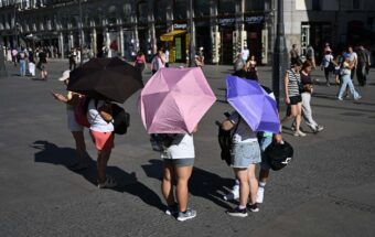 People protect themselves from the heat wave that affects daily life as high temperatures continue, on June 26, 2026, in Madrid, Spain.