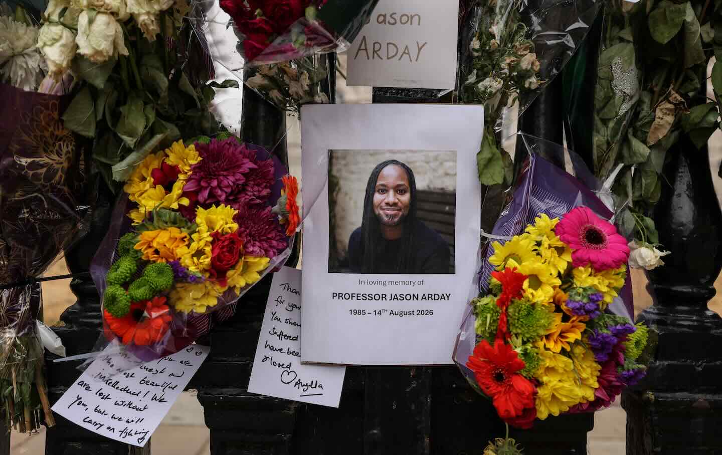A photo of late Cambridge professor Jason Arday is pictured along with floral tributes that are attached to the fencing around the Senate House at the University of Cambridge on August 18, following his death at age 41 on August 14.