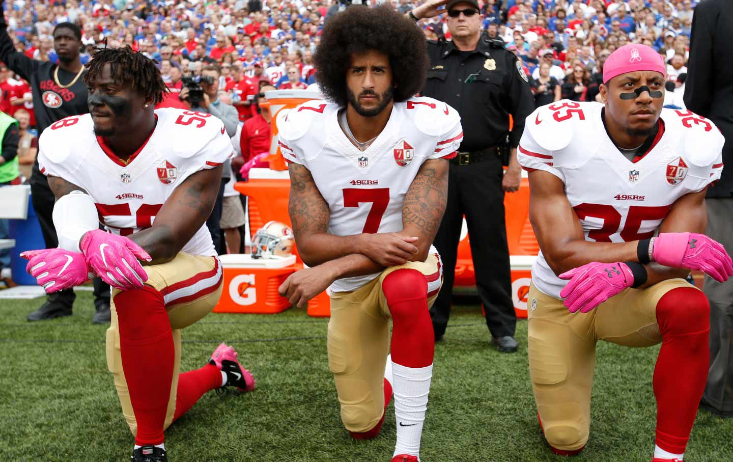 Eli Harold, Colin Kaepernick, and Eric Reid of the San Francisco 49ers kneel in protest during the anthem in October 2016 in New York.