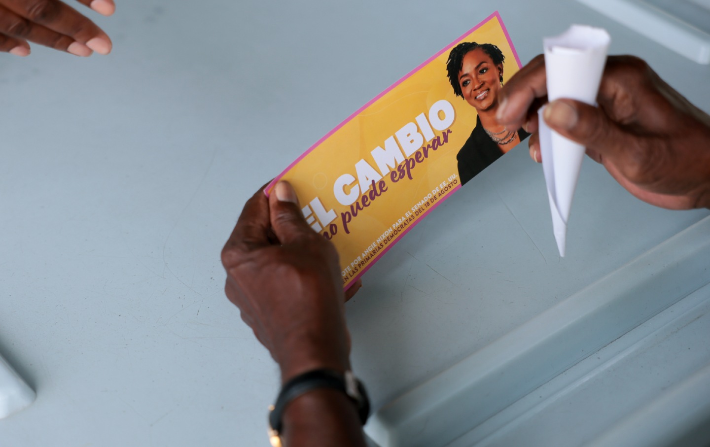 A supporter holds a campaign brochure supporting Democratic US Senate candidate Angie Nixon in Miami, Florida, on August 15, 2026. The brochure reads, in Spanish, “Change can’t wait.”