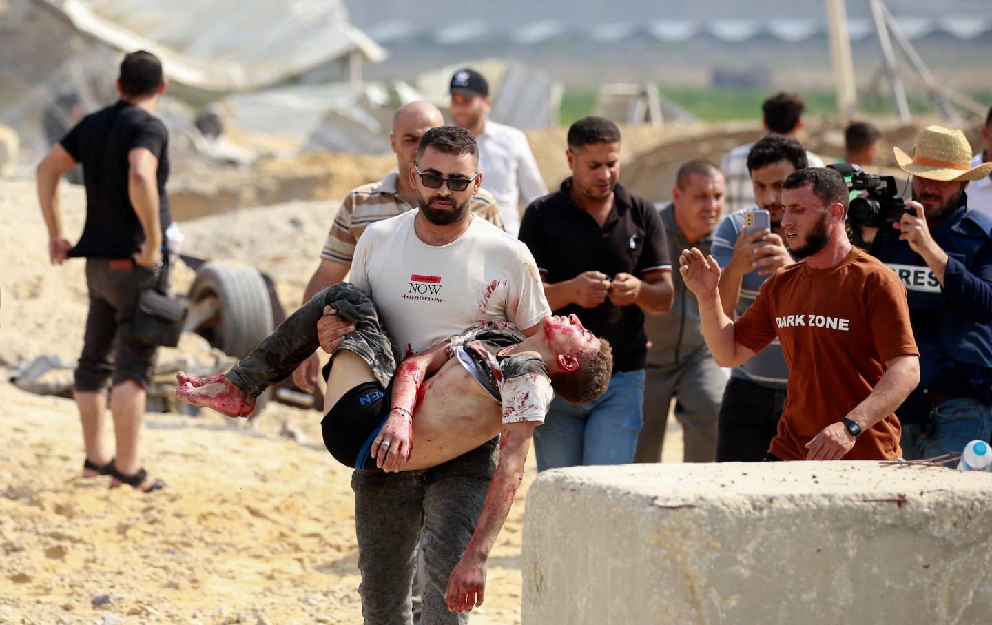 A man carries away a Palestinian killed in an Israeli airstrike at the Erez crossing between Israel and the northern Gaza Strip, on October 7, 2023.